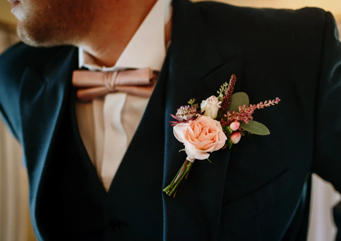 Martin's buttonhole pinned in place on the groom's lapel on the morning of his wedding at Doddington Hall, Lincolnshire