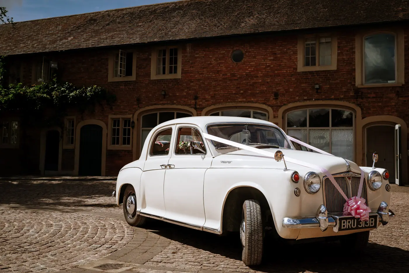 The wedding car waiting outside the brewhouse at Doddington Hall, Lincolnshire on the morning of Louise and Martin's wedding