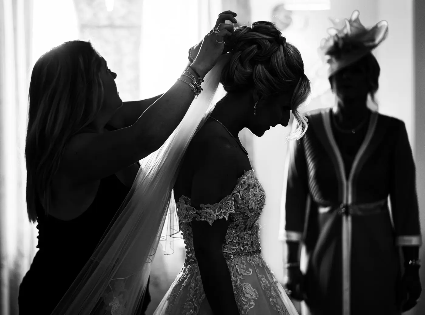 Silhouette of bride Louise having her veil fitted on her wedding morning at Doddington Hall, Lincolnshire