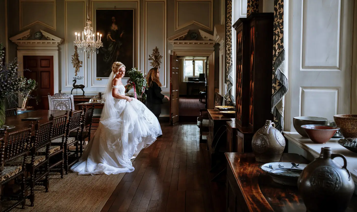 Bride Louise making her way through the stunning interior of Doddington Hall, Lincolnshire on her wedding day