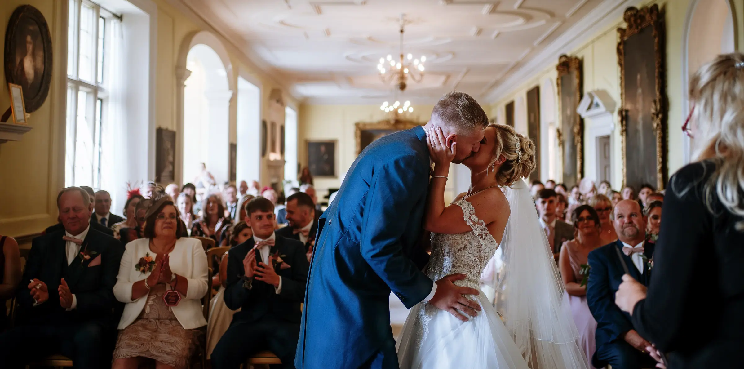 The first kiss. Louise and Martin share their first kiss as a married couple in the Long Gallery at Doddington Hall, Lincolnshire, photographed by Gary Phillip