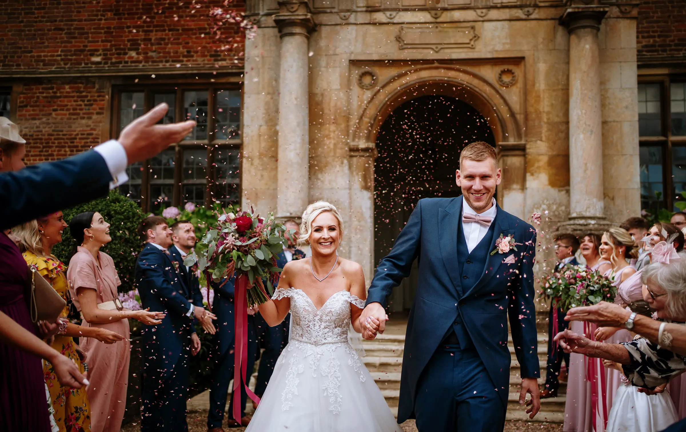 Confetti time outside the main door of Doddington Hall as Louise and Martin celebrate their marriage surrounded by family and friends in Lincolnshire