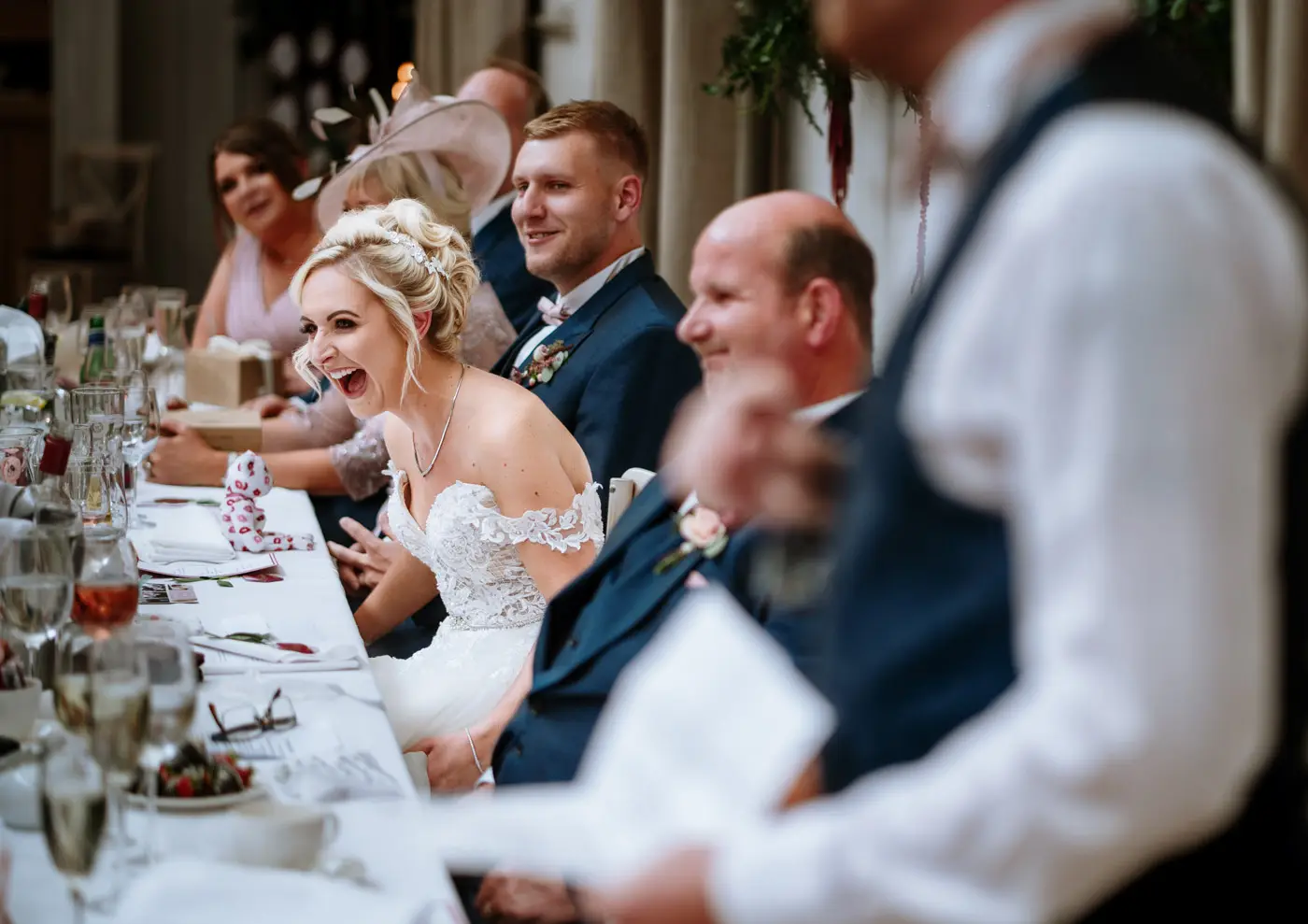Bride Louise in fits of laughter during the wedding speeches at Doddington Hall, Lincolnshire, documentary wedding photography by Gary Phillip