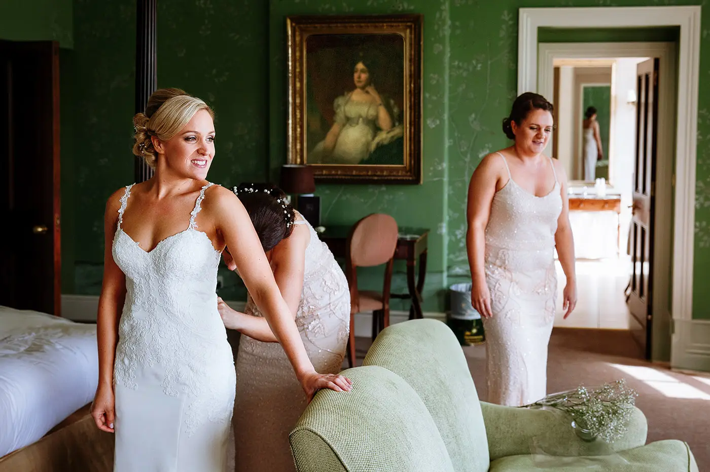 Bridesmaid helping bride Sally into her wedding dress at Stubton Hall, Nottinghamshire, an honest preparation moment captured by documentary photographer Gary Phillip