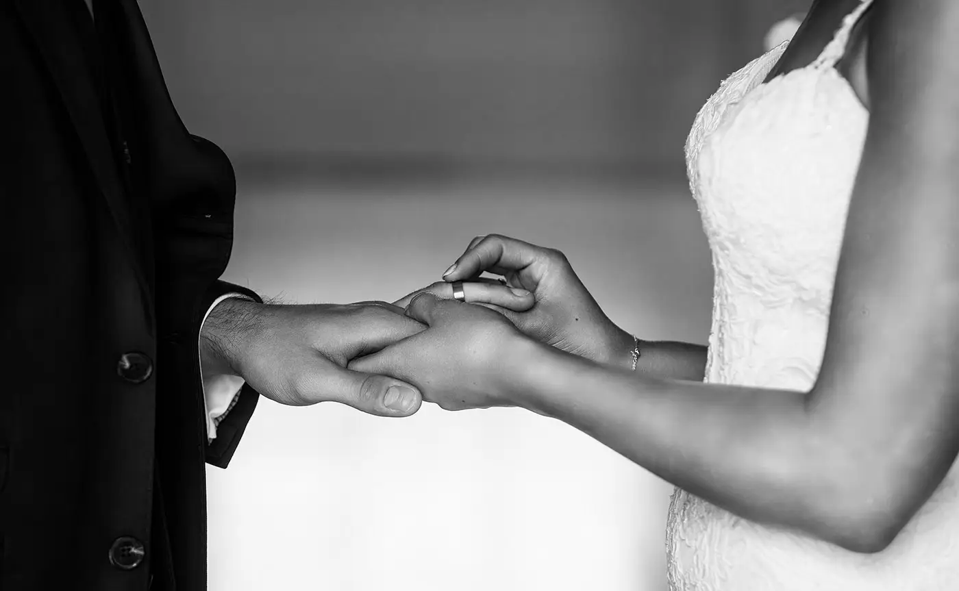 Close detail of bride Sally pushing the wedding ring onto groom Luke's finger at Stubton Hall, Nottinghamshire, an intimate ring ceremony detail by Gary Phillip