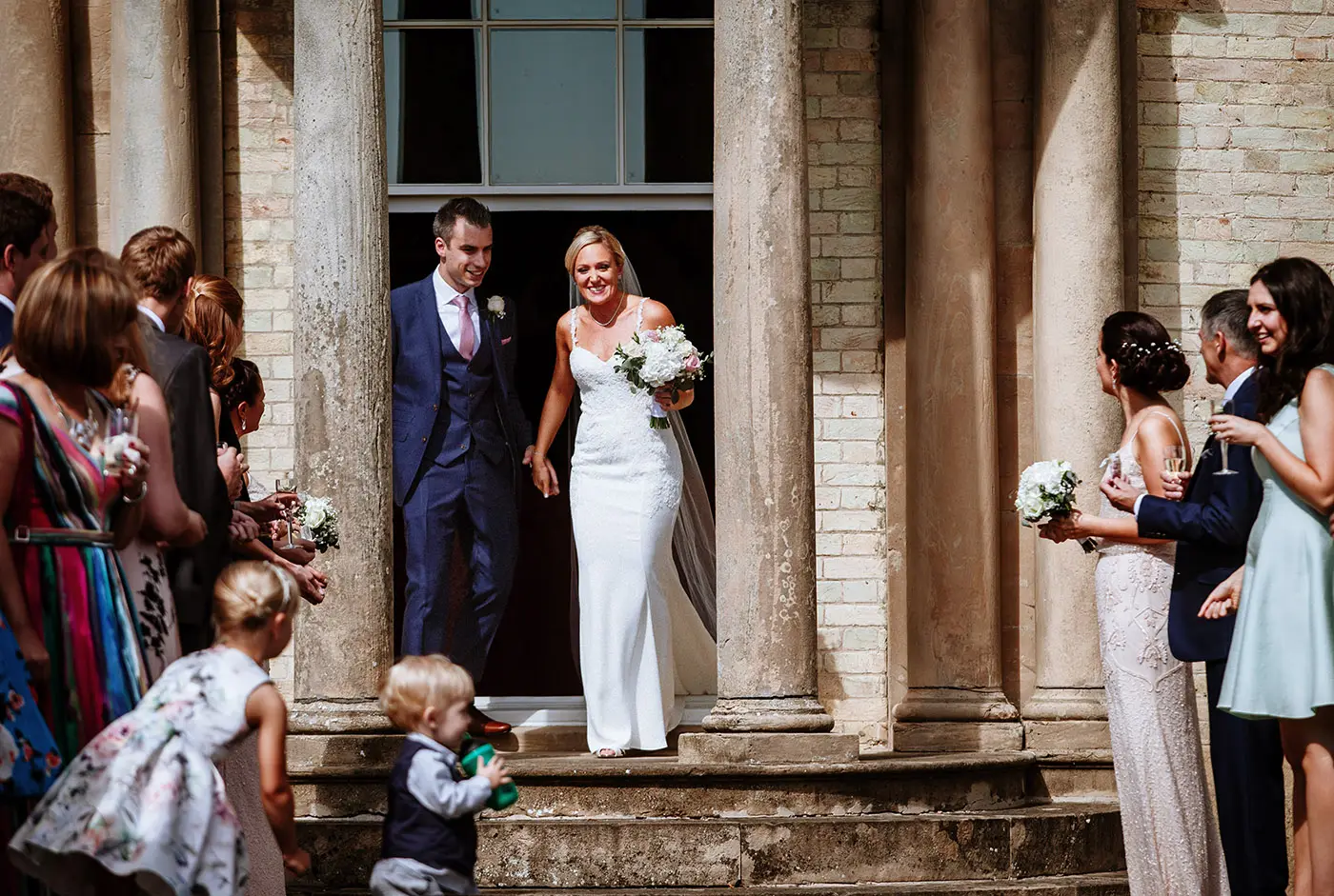 Bride Sally and groom Luke emerging from Stubton Hall ready for the confetti gauntlet, documentary wedding photography by Gary Phillip, Nottinghamshire