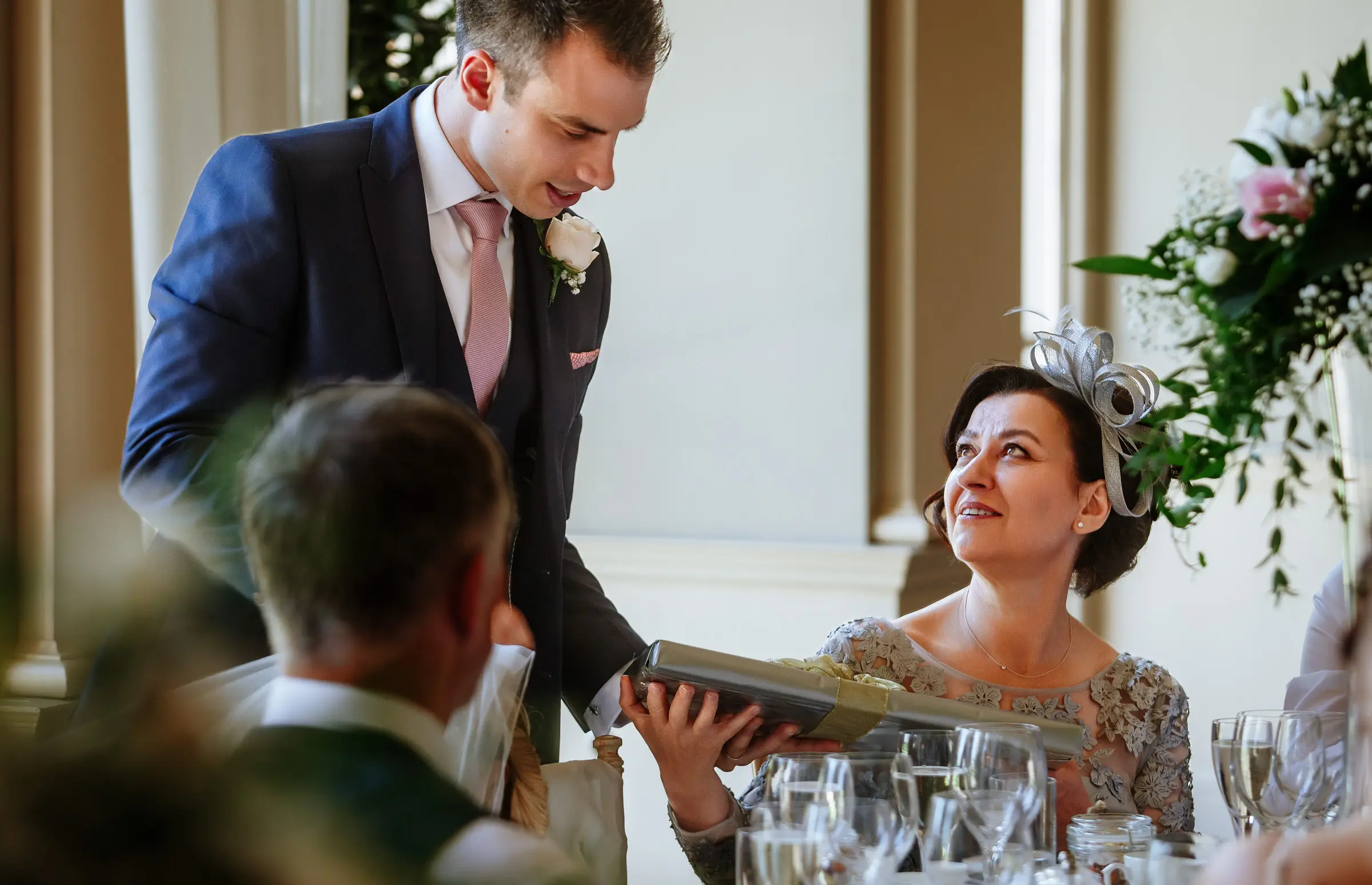 Groom Luke presenting a gift to his mother during his wedding speech at Stubton Hall while his mother's eye fills with tears, a deeply moving moment by Gary Phillip