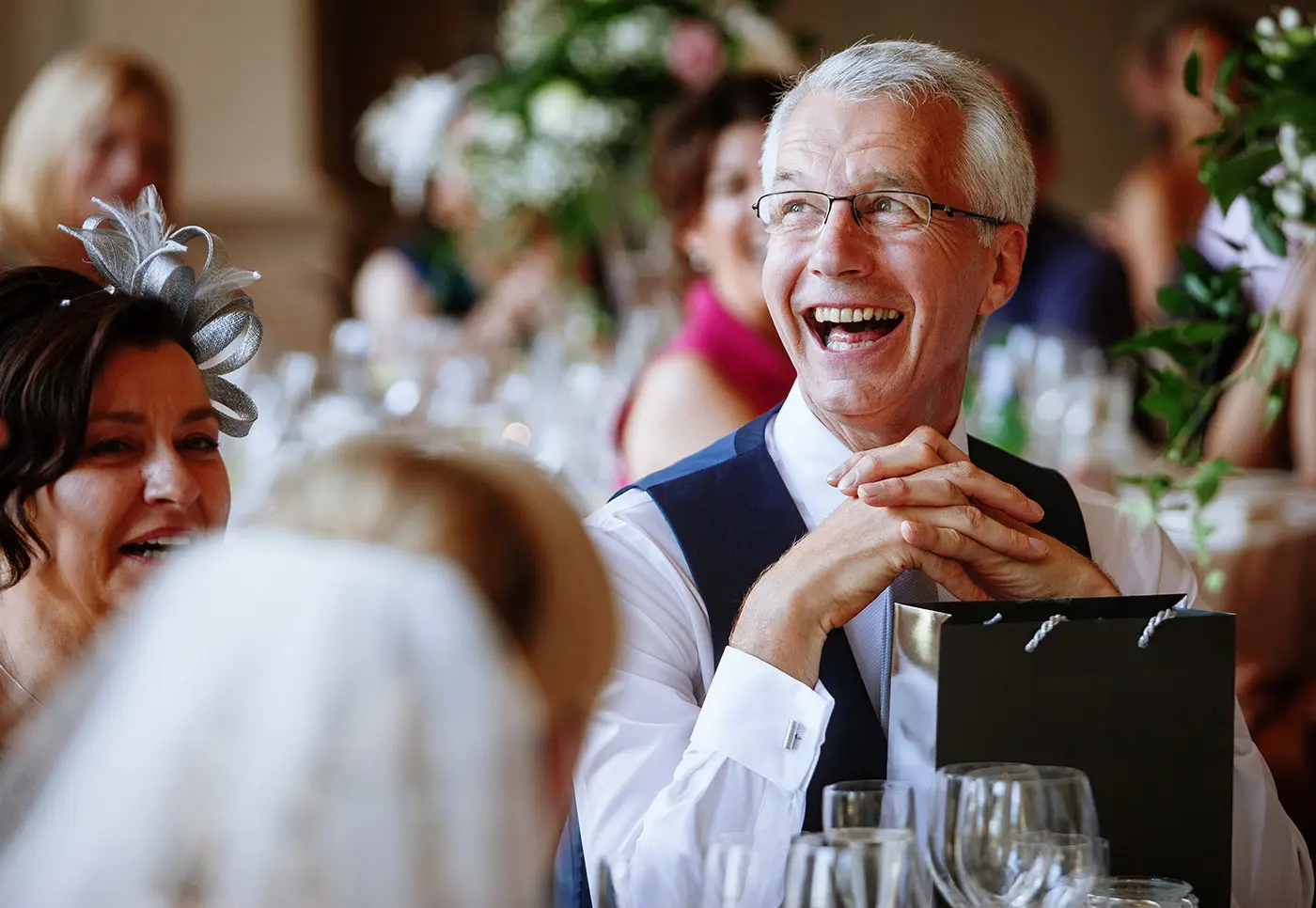 Father of the groom laughing during the wedding speeches at Stubton Hall, Nottinghamshire, a joyful candid moment by documentary photographer Gary Phillip
