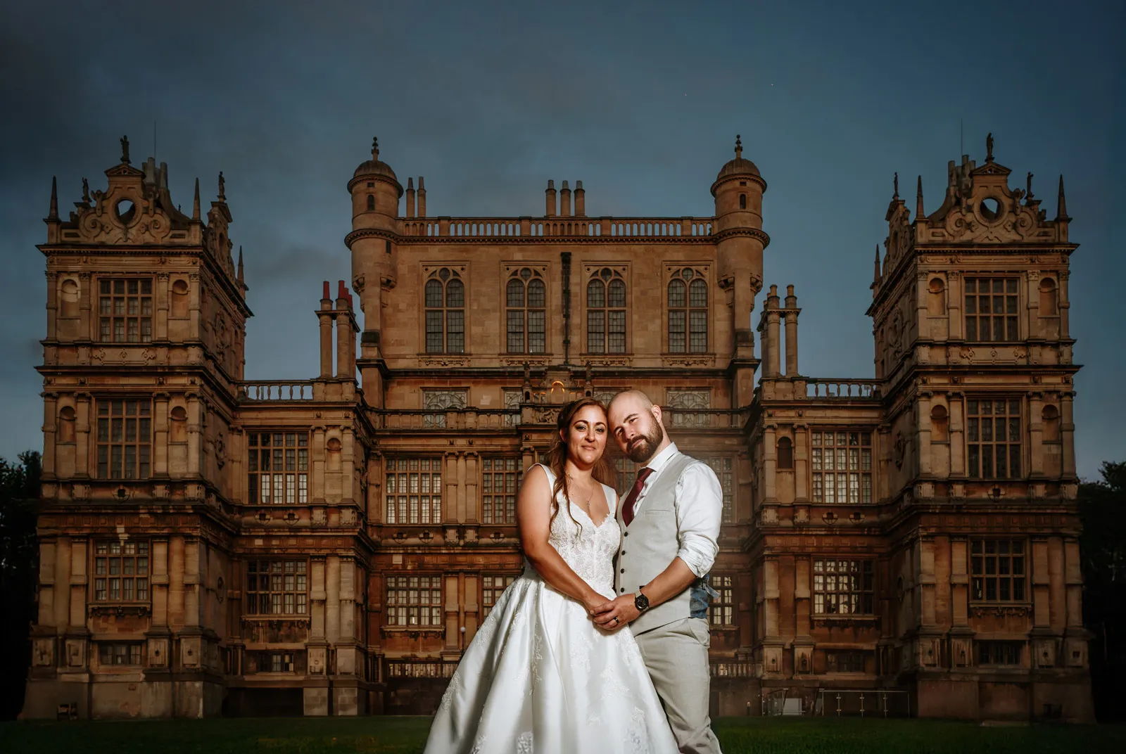 Amy and Andy in front of Wollaton Hall at dusk — off-camera flash against the Elizabethan facade
